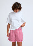Naomi mesure 1m70 et porte le t-shirt en taille XS et le short en taille XS/S.