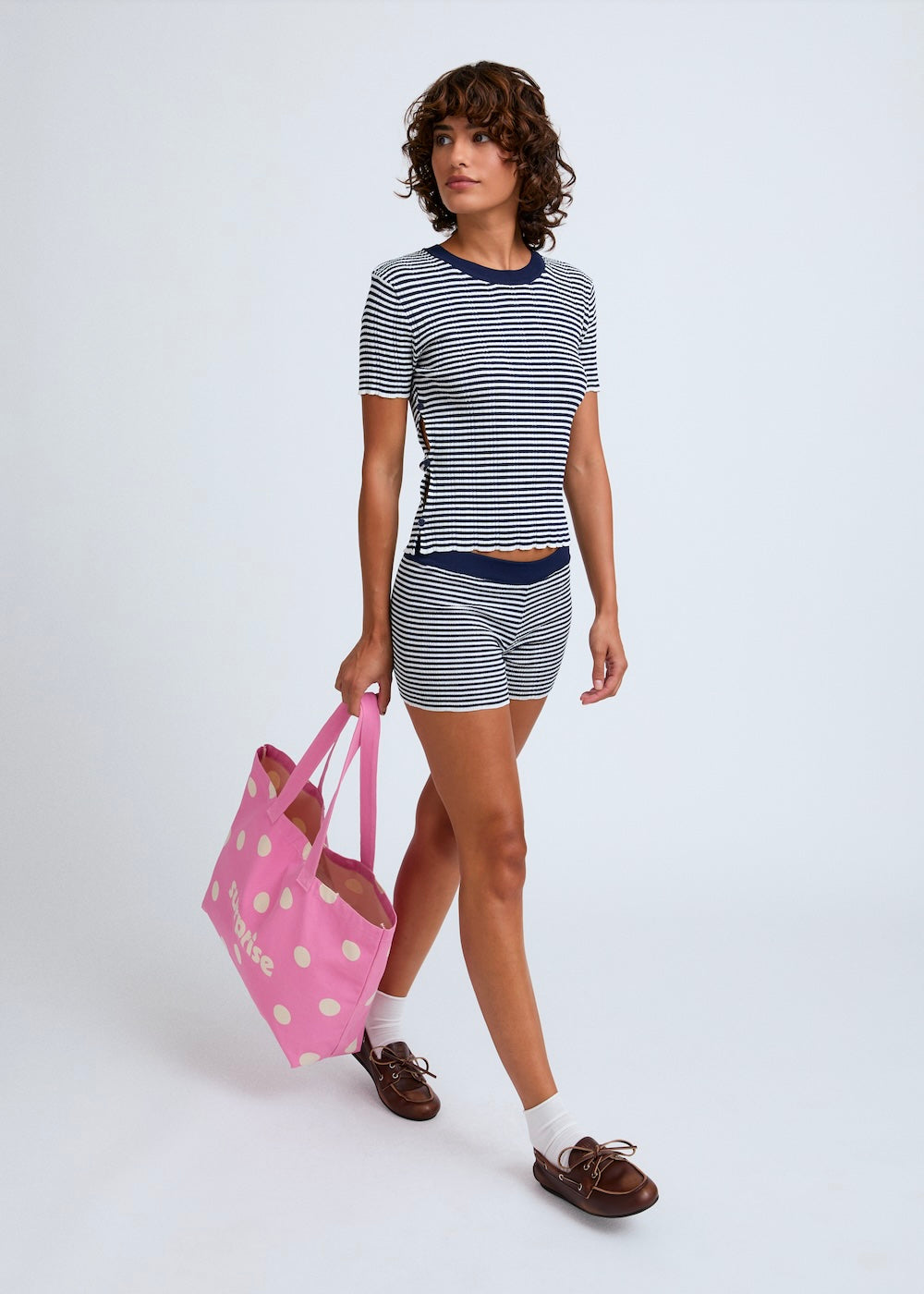 Naomi mesure 1m70. Elle porte le t-shirt en taille 1 et le short en XS/S.
