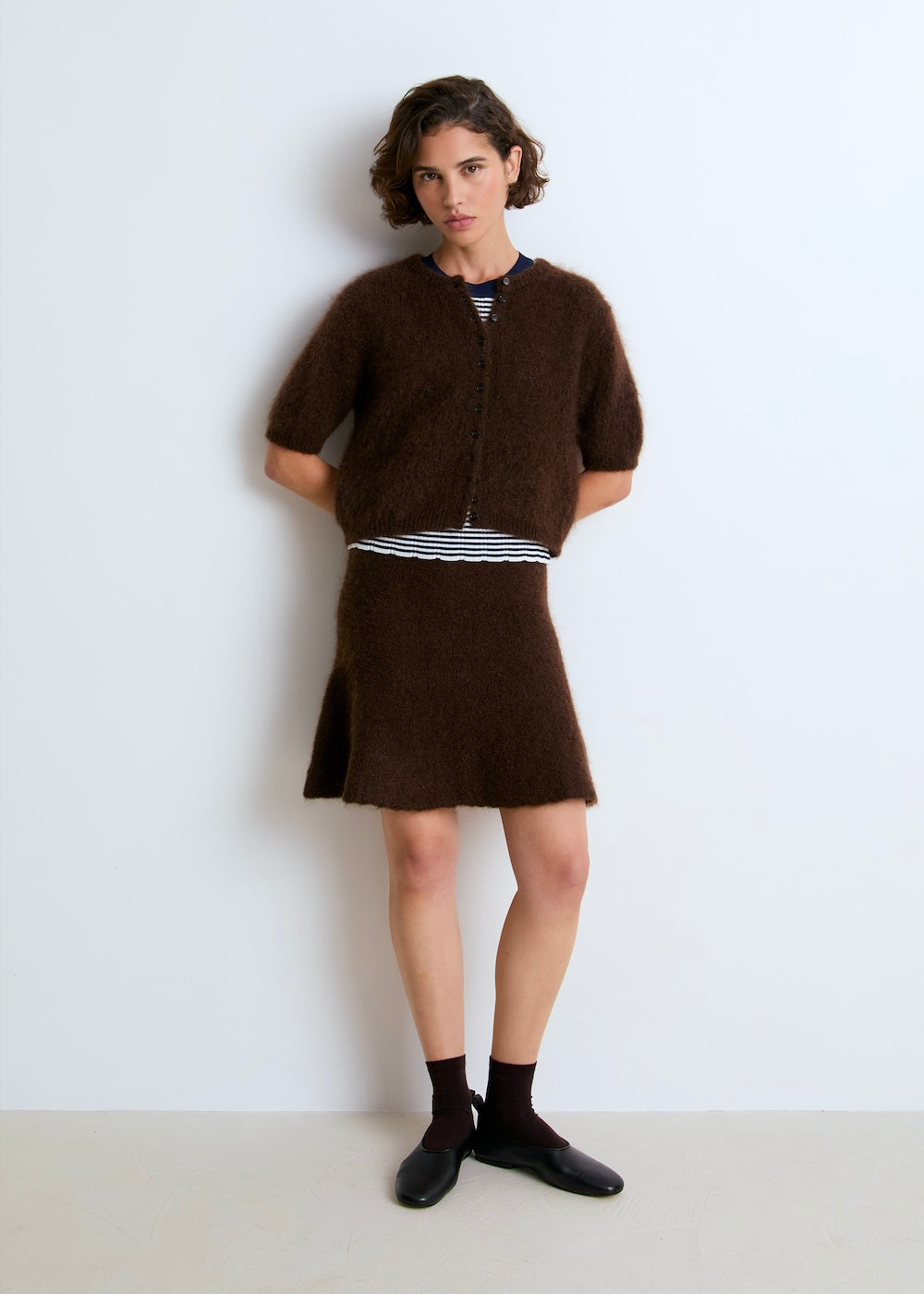 Lala mesure 1m74 et porte le cardigan en taille S et la jupe en taille XS.