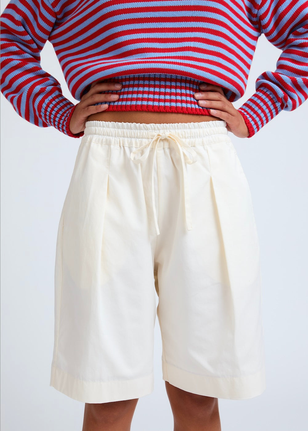 Naomi mesure 1m70 et porte le pull en taille XS et le short en XS/S.