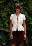 Naomi mesure 1m70 et porte la blouse en XS/S et la jupe en XS.