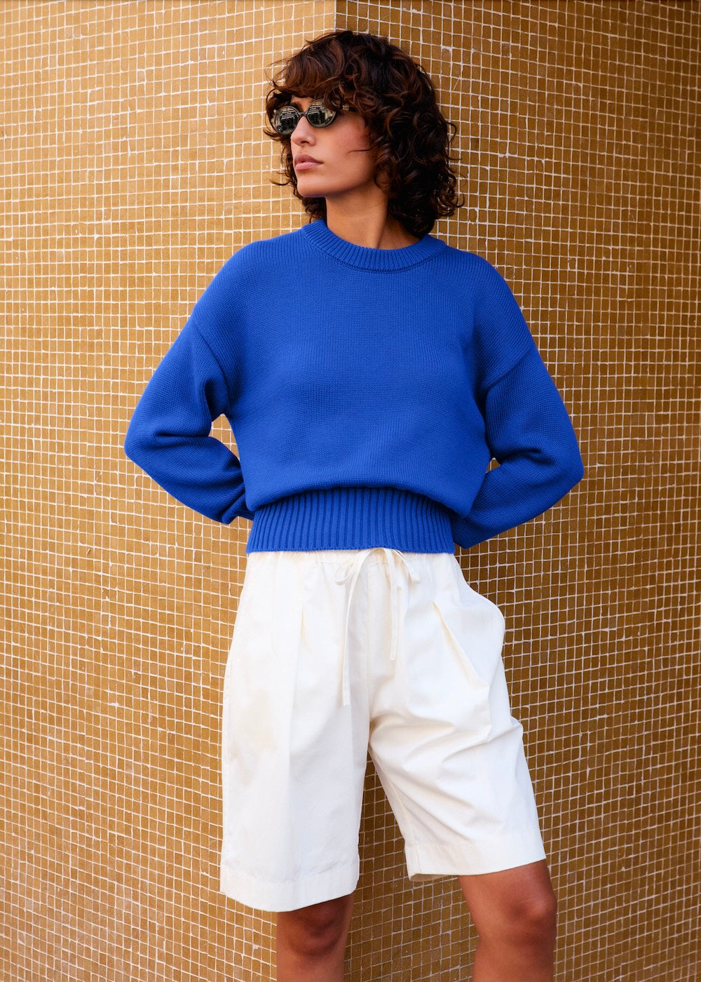 Naomi mesure 1m70 et porte le pull en taille XS et le short en XS/S.