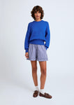 Naomi mesure 1m70 et porte le pull en taille XS et le short en XS/S.