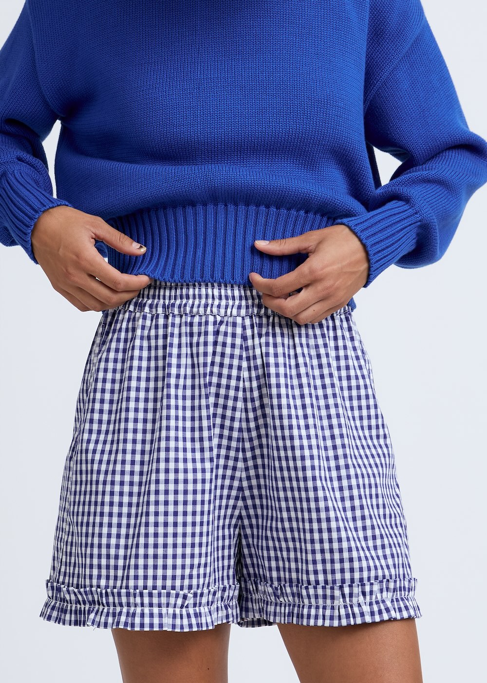 Naomi mesure 1m70 et porte le pull en taille XS et le short en XS/S.